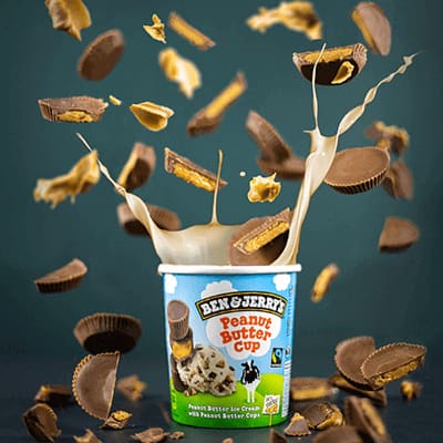 A Pint of Peanut Butter Cup with caramel dripping down the side onto the table